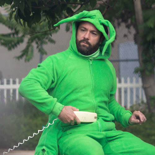 Photo of actor in grasshopper suit with corded telephone