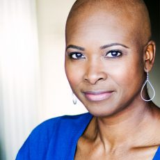 Better Hart - black woman with no hair and bright blue sweater